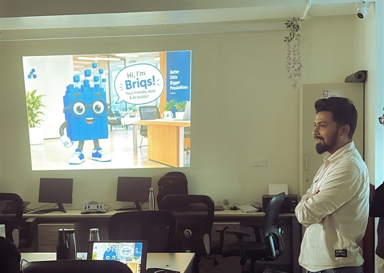 Dev presenting Briqs, the Brilliqs mascot, at its internal launch